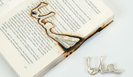 Ein Buch wurde als Gußform für Metall benutzt. In die Seiten wurde der Schriftzug "Bla" gegossen.