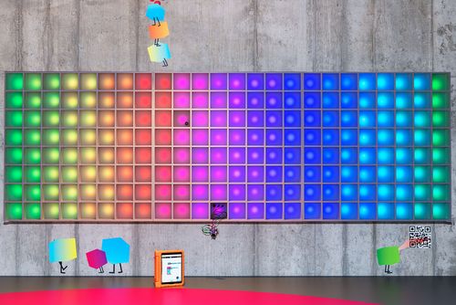The pixel display wall is illuminated in rainbow colors.