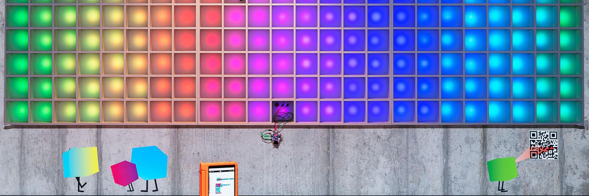 Die Pixelwand leuchtet in Regenbogenfarben.
