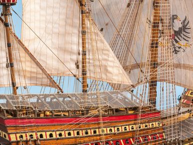 Close-up of a highly detailed model ship with raised sails.