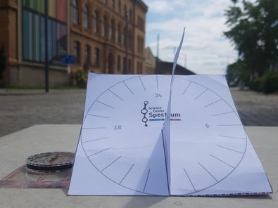 eine selbst gebastelte Sonnenuhr aus Papier zeigt die Uhrzeit an
