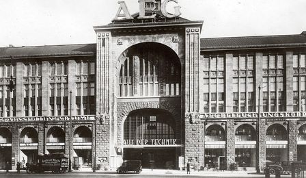 Ein Schwarzweiß-Foto zeigt das beeindruckende Eingangsportal eines Gebäudes, das an ein vornehmes Kaufhaus oder an einen Palast erinnert.