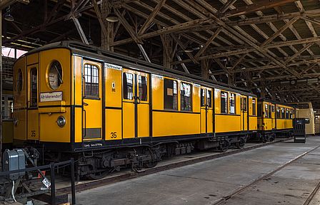 Der gelbe Triebwagen der Baureihe BI von 1924 steht auf dem Gleis im Depot für Straßenverkehr des Deutschen Technikmuseums in der Monumentenhalle.