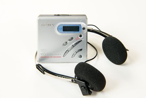 This MZ-R500 MiniDisc Recorder has the shape of a small square box with asymmetrically arranged function keys and a silver colored aluminum surface.