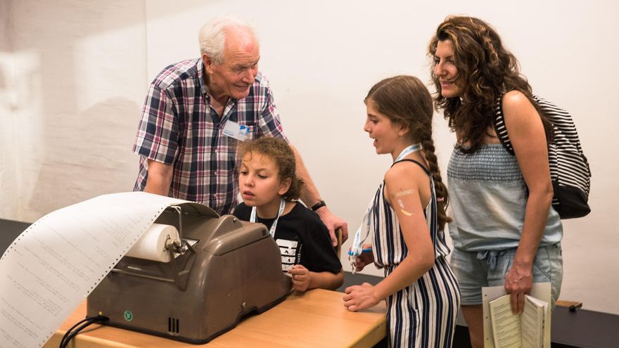 Ein älterer Mann erklärt drei jungen Frauen die Funktion eines Fernschreiber-Gerätes. Eine typische Situation bei der Langen Nacht der Museen, bei der auch Mitglieder des Fördervereins aktiv sind.