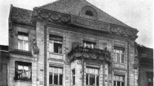 Das Foto zeigt die Fassade des 1907 erbauten Firmensitzes mit der Inschrift „Paul Pittius“. 