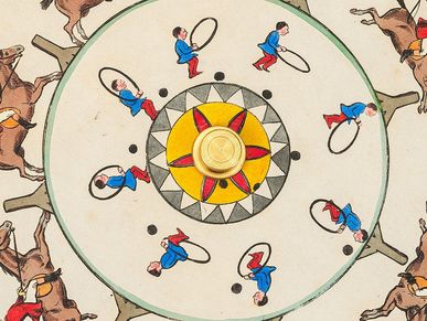 Detail of a cardboard disc with various illustrations arranged in a circle. On the outside, a galloping horse and rider can be seen. On the inside there is a little man jumping through a hoop.