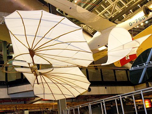 Der Nachbau eines Segelapparats von Otto Lilienthal hängt in der Luftfahrtausstellung des Deutschen Technikmuseums. Er besteht aus einer mit weißem Stoff bespannten Holzkonstruktion. 