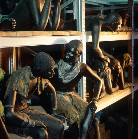 Das Auustellungsmodul zum Versklavungshandel zeigt in Farbe gefasste Figuren, die versklavte afrikanische Männer, Frauen und Kinder repräsentieren sollen, symbolisch wie Waren in einem Regal gestapelt. 