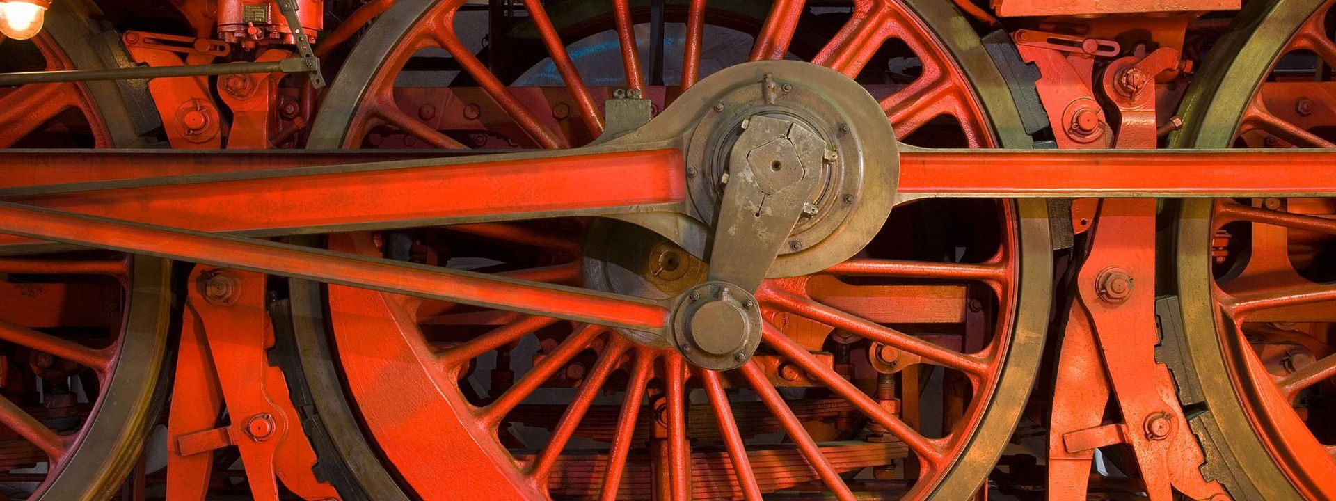 Nahaufnahme von großen, rot gestrichenen Rädern einer historischen Lokomotive. 