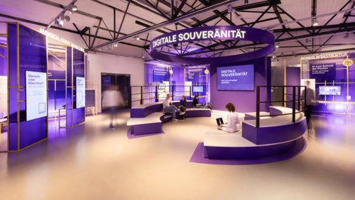 Blick in den Erlebnisraum Digitale Souveränität mit lila Podesten und Ausstellungseinheiten