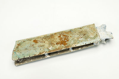 The wreckage of a World War II glide bomb is made of metal. It is rectangular and partially rusted.
