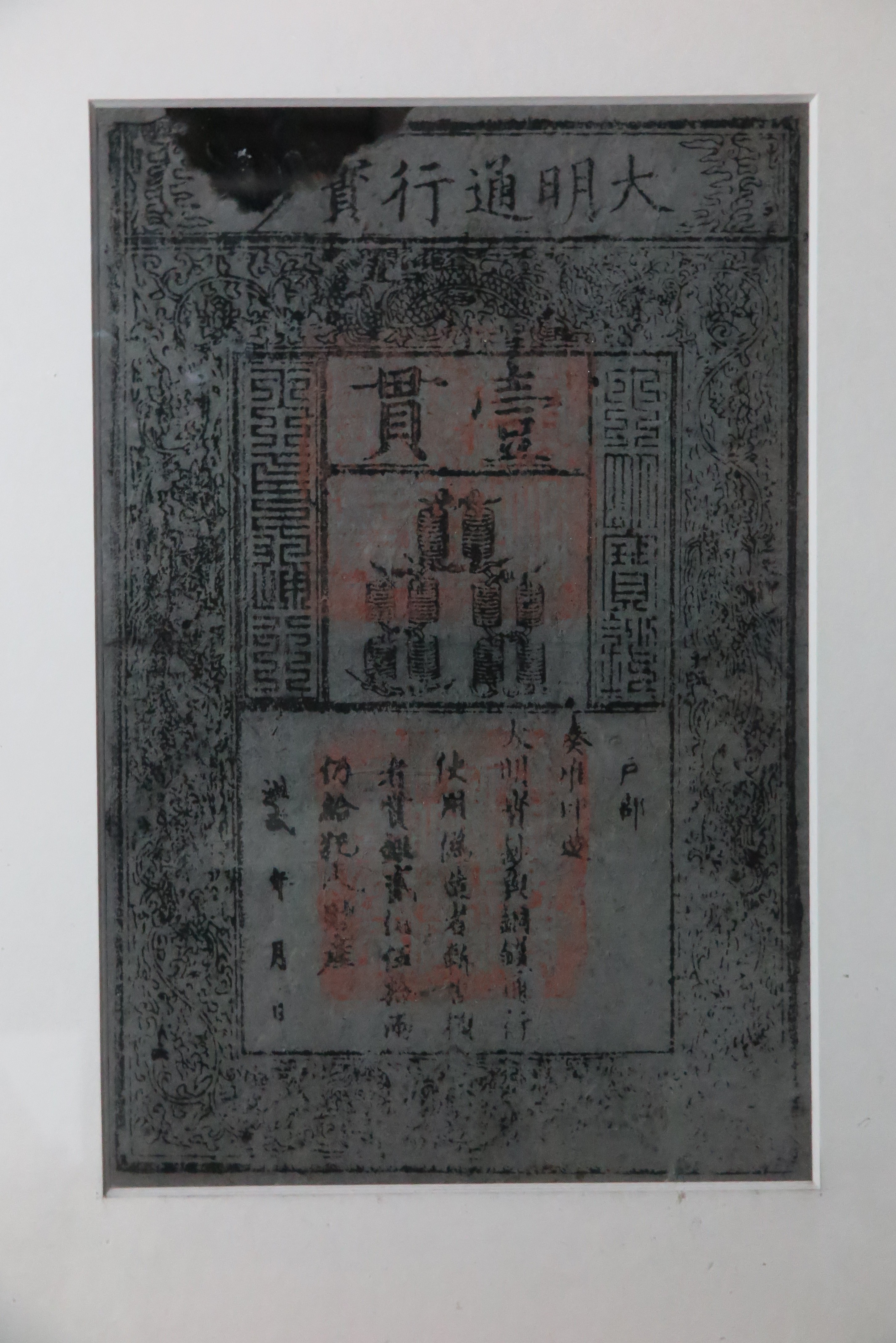 Large paper bill featuring Chinese characters and motifs