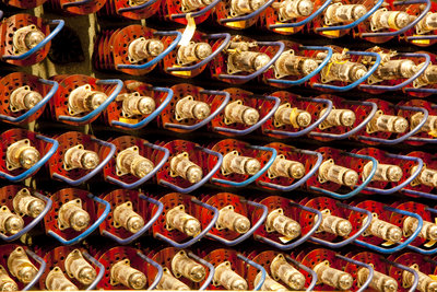 Filling the frame: red fluorescent tubes with gold-colored metal caps and blue brackets