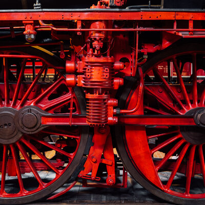 Nahansicht von roten Eisenbahnrädern auf einer schwarzen Lok