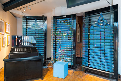 The three memory cabinets of the replica of the Zuse Z3 computer are each 2.20 meters high and 1.20 meters wide and are equipped with a total of 1,600 blue relays. In the foreground on the left is the black control console with numerous numeric and function keys.
