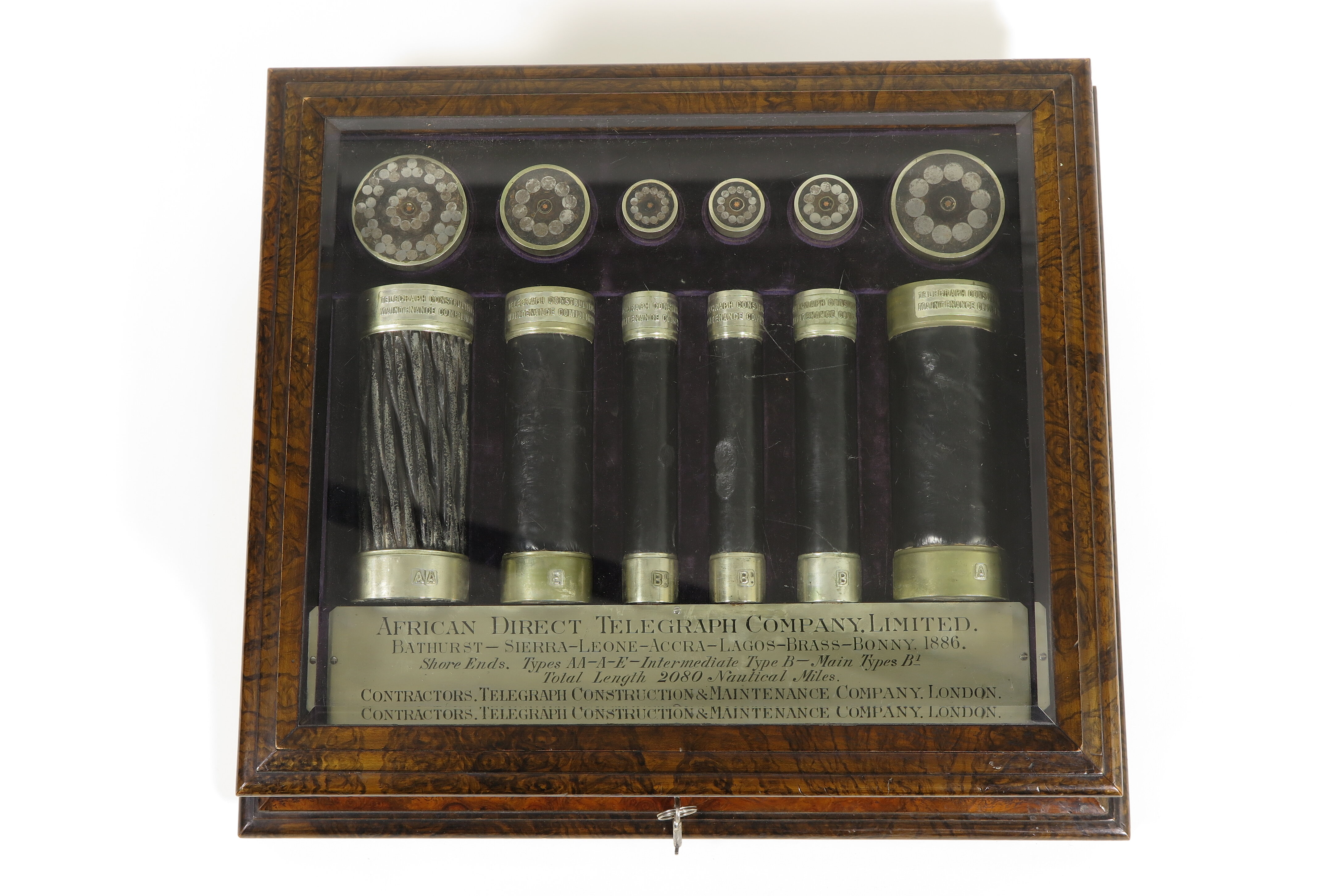 Hölzerne Schmuckschatulle der African Direct Telegraph Company mit 12 unterschiedlich großen Teilen von Telegrafenkabeln.