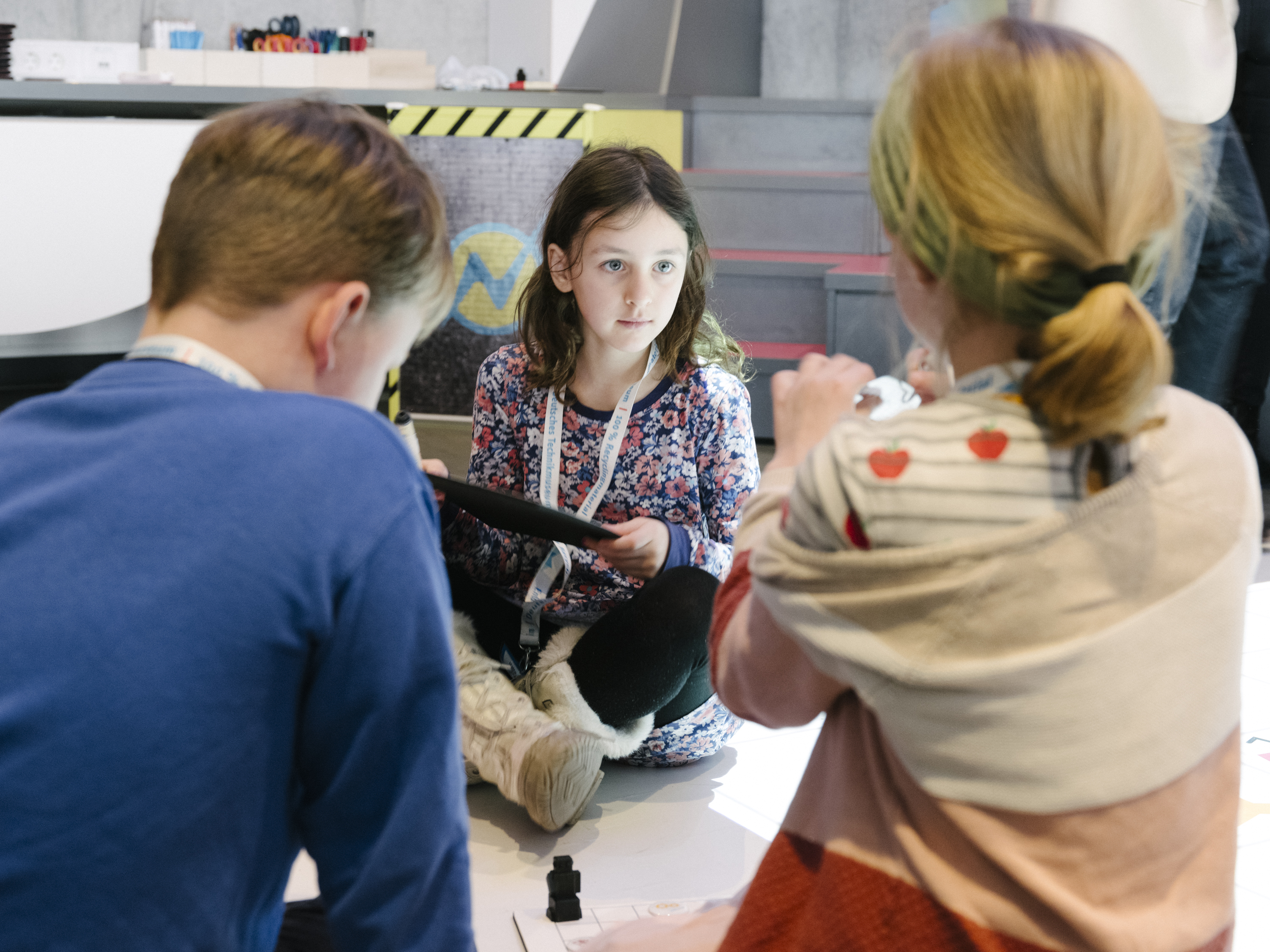 Drei Kinder im kids.digilab.berlin. Ein Mädchen hält einen Labtop.