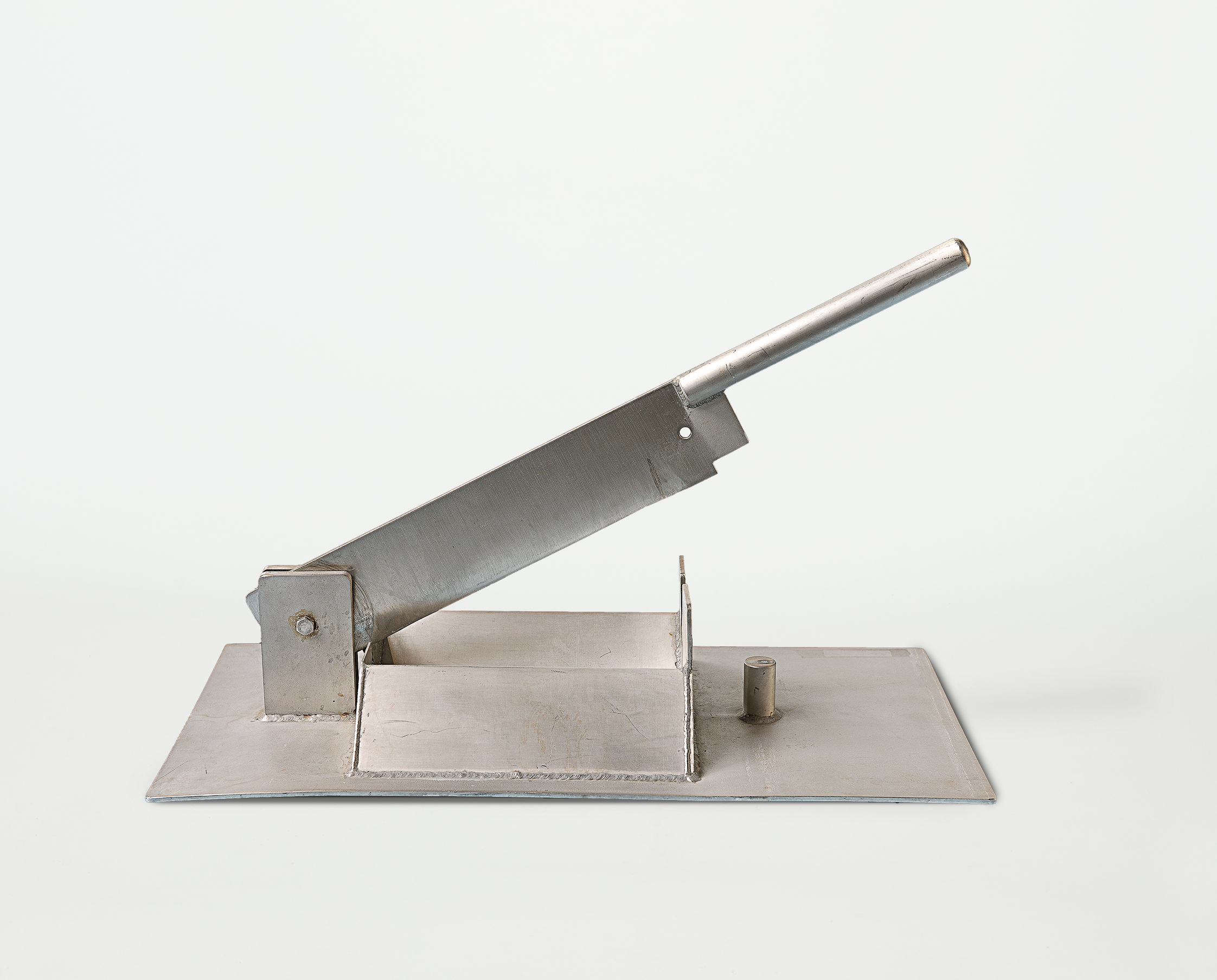 Der Stierhodenschneider wurde um 1950 von der Firma Schering gebaut. Es handelt sich um eine besonders stabile Schlagmesserklinge, die auf eine Metallplatte montiert ist, und mit einem Metallgriff an der Seite heruntergedrückt wird.