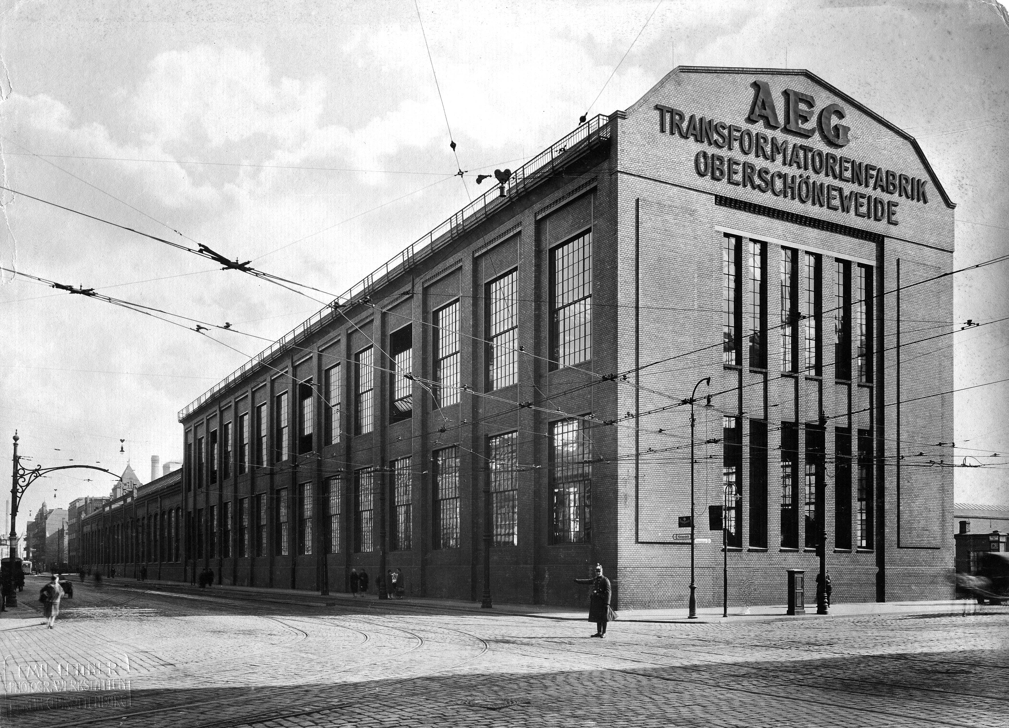 Ein kathedralenartiges Farbrikgebäude mit dem Schriftzug "AEG"