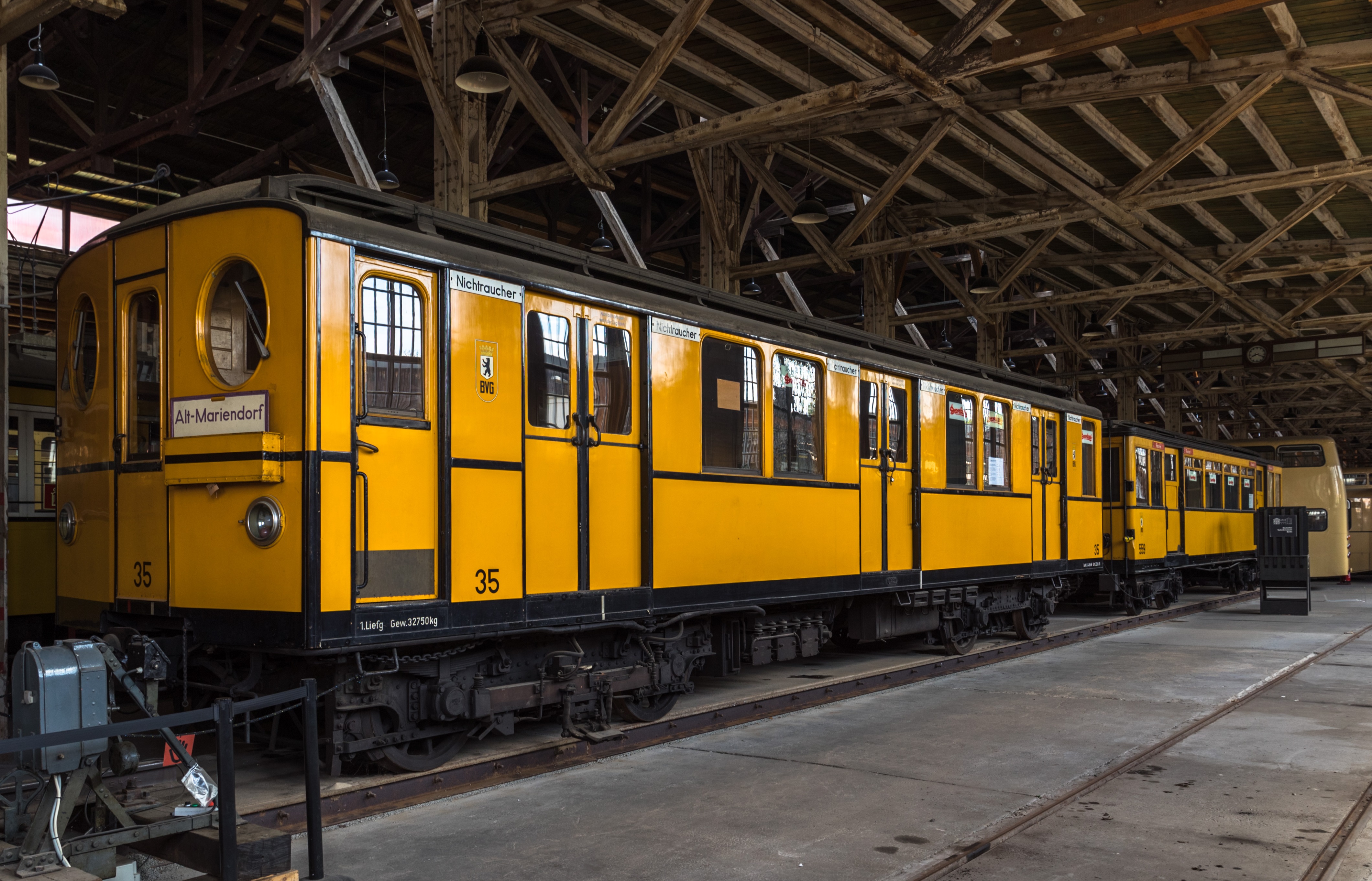 Der gelbe Triebwagen der Baureihe BI von 1924 steht auf dem Gleis im Depot für Straßenverkehr des Deutschen Technikmuseums in der Monumentenhalle.