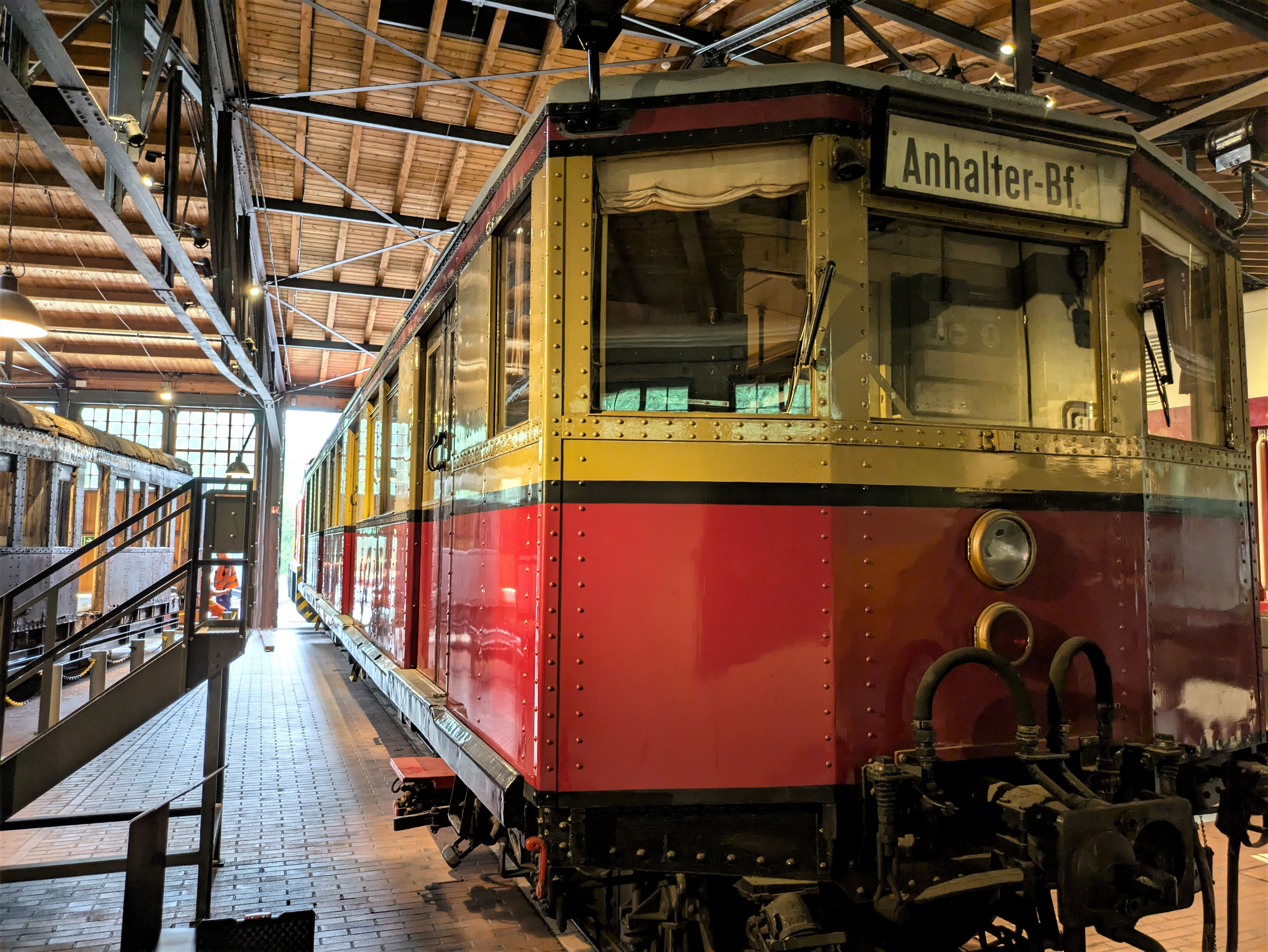 Foto eines gelb-roten S-Bahn-Wagens in einem Lokschuppen.