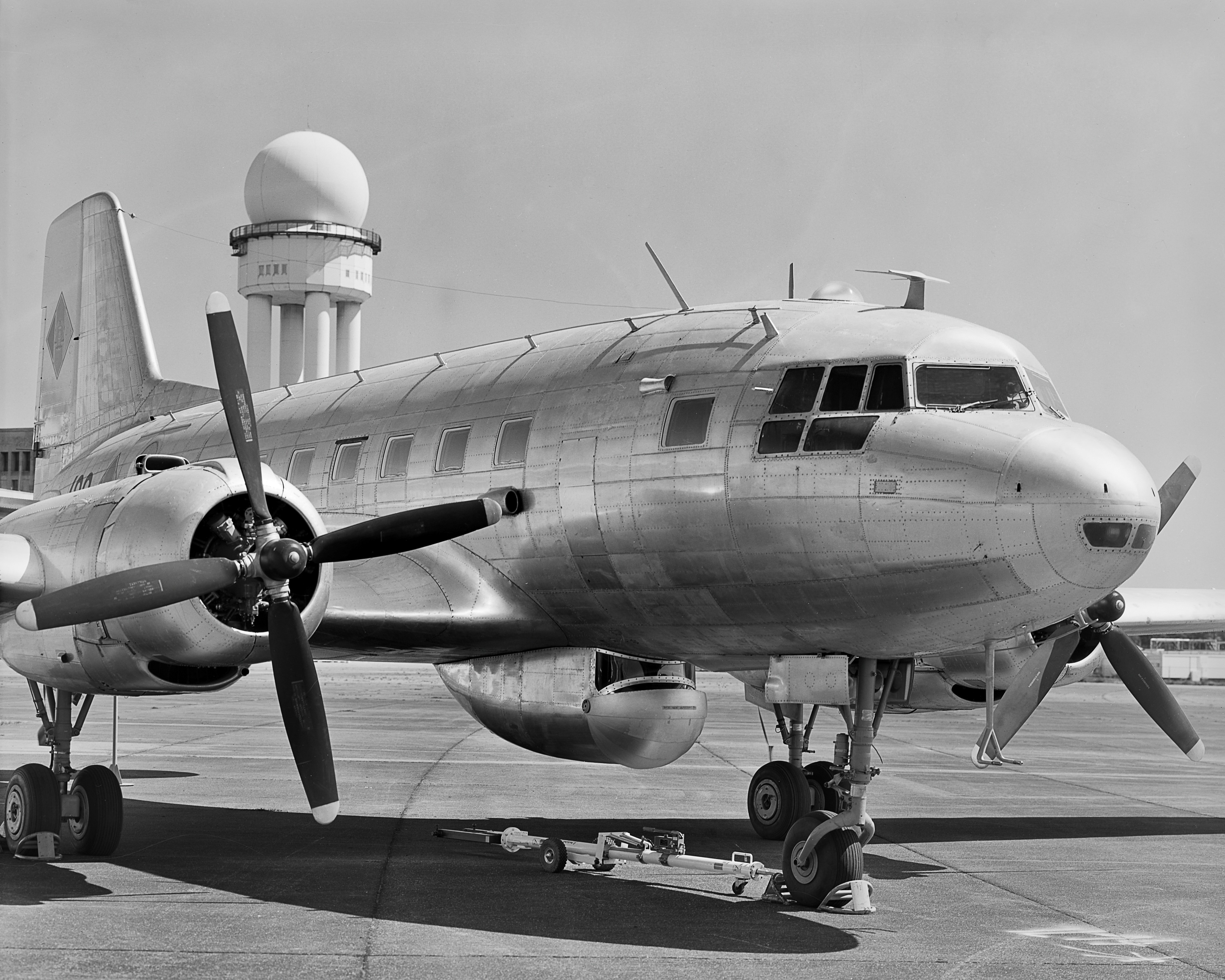 Schwarzweiss-Foto: Blick auf ein Flugzeug des Typs Iljuschin IL-14P in restauriertem Zustand.