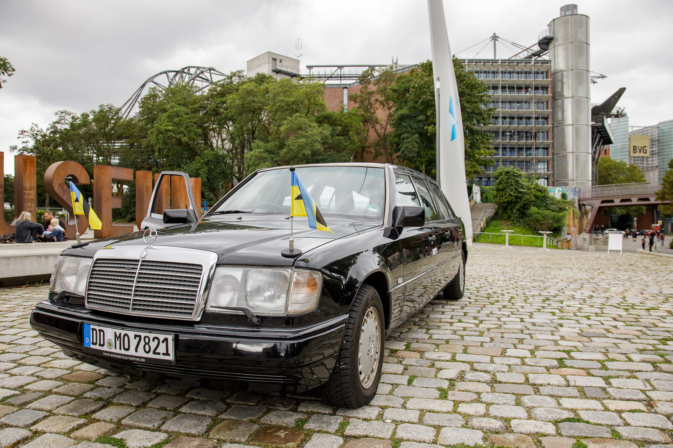 Schwarze Limousine auf dem Vorplatz des Museums, im Hintergrund ist das Gebäude mit Rosinenbomber zu erkennen.