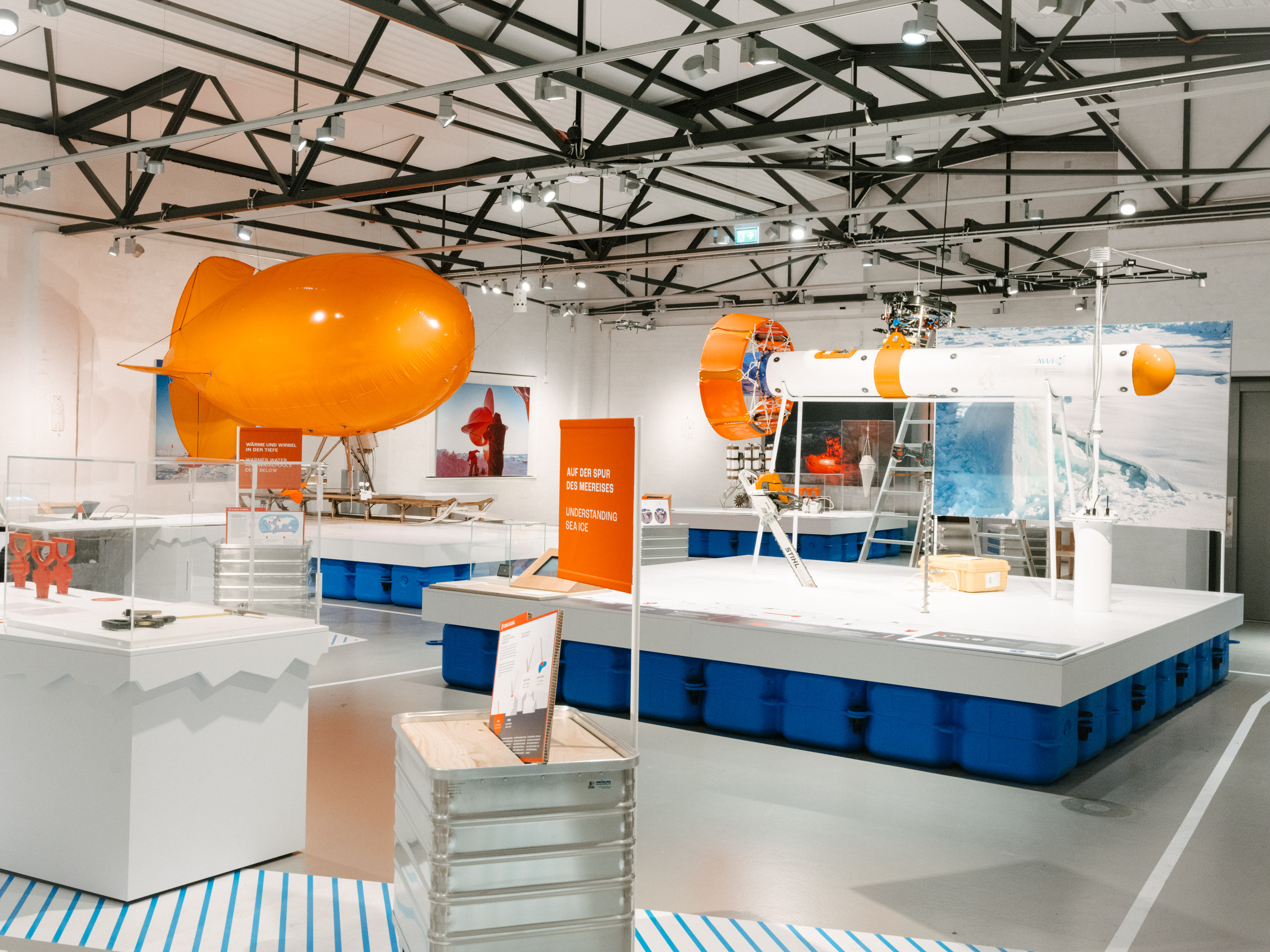 A view of the exhibit. On the left is an orange tethered balloon; on the right is an elongated measuring probe. The exhibit displays are mounted on "clods."