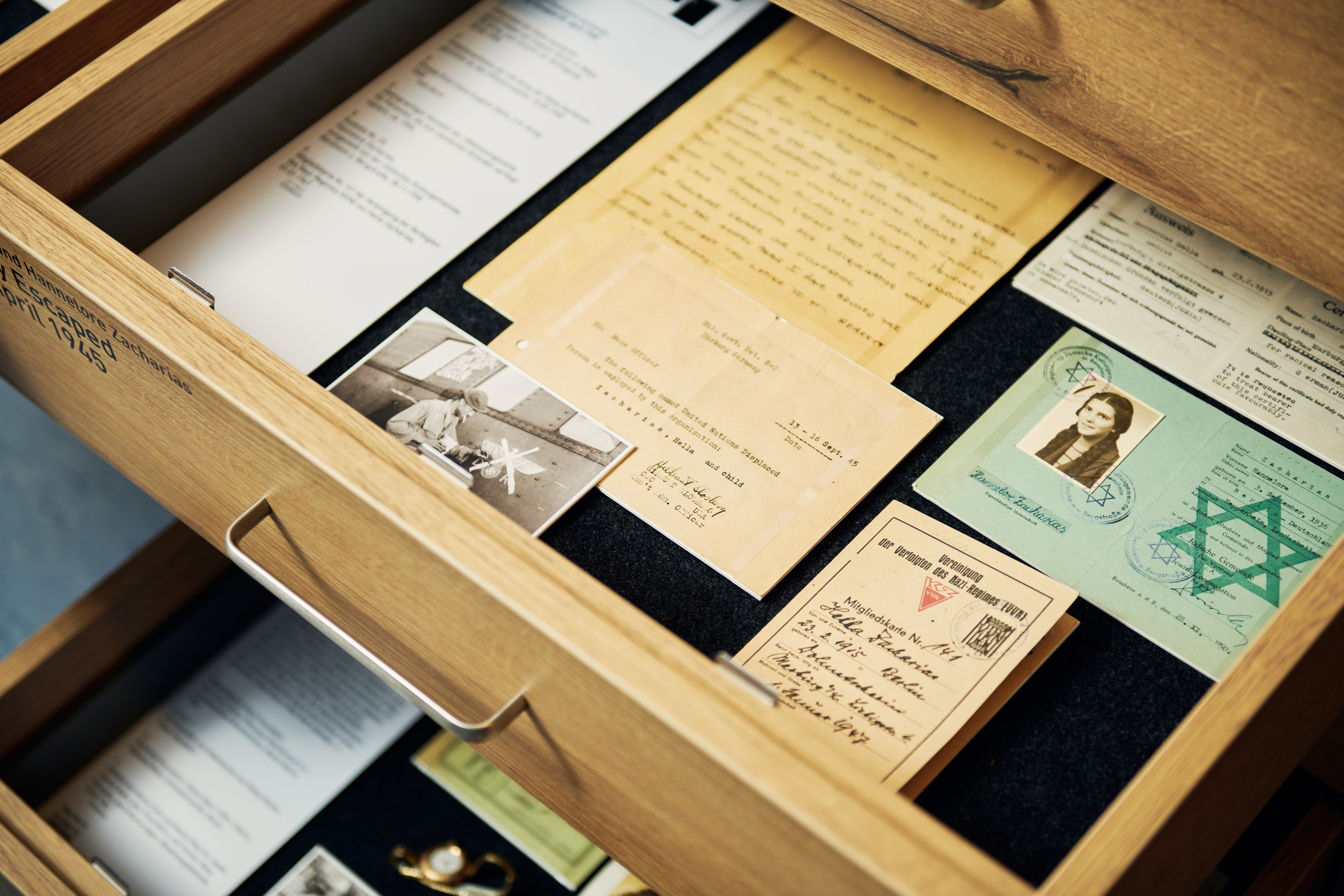 A view inside two open drawers containing documents belonging to Hella and Hannelore Zacharias. Identity cards can be seen; one bears the Jewish star.