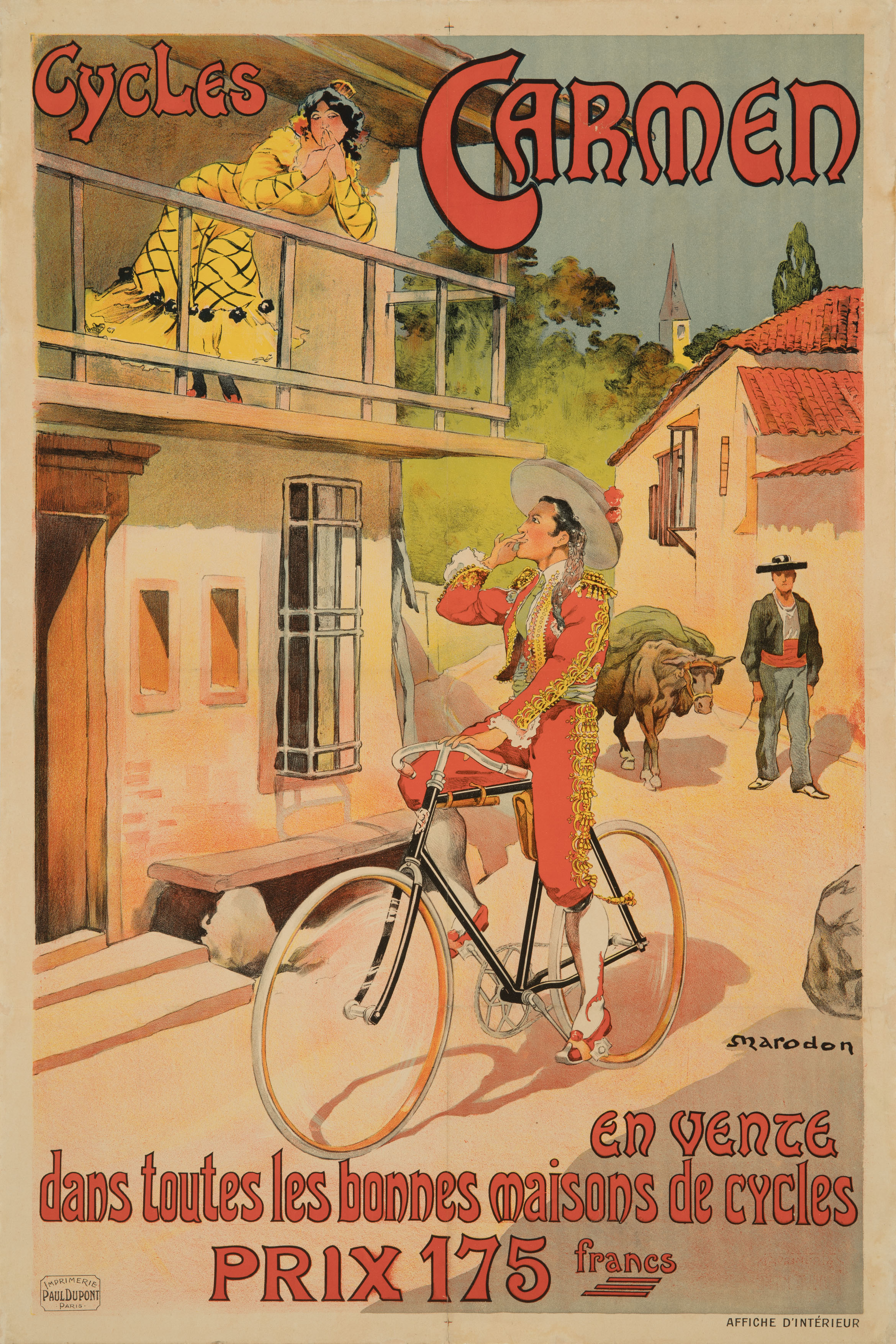 Das Plakat zeigt eine Szene in einem spanischen Dorf. Links ein Haus. Auf dessen Balkon steht eine Spanierin im gelb-schwarzen Kleid. Sie lehnt sich auf die Balustrade und schaut kokett zum Betrachter. Sie umrahmt der Schriftzug „Cycles Carmen“. Vor dem Haus fährt ein Spanier im rot-goldenen Trachtenanzug auf einem schwarzen Fahrrad. Er schaut zu der Frau hoch und wirft ihr einen Kussmund zu. Im Hintergrund sieht man einen spanischen Bauern mit einem Lastochsen.
