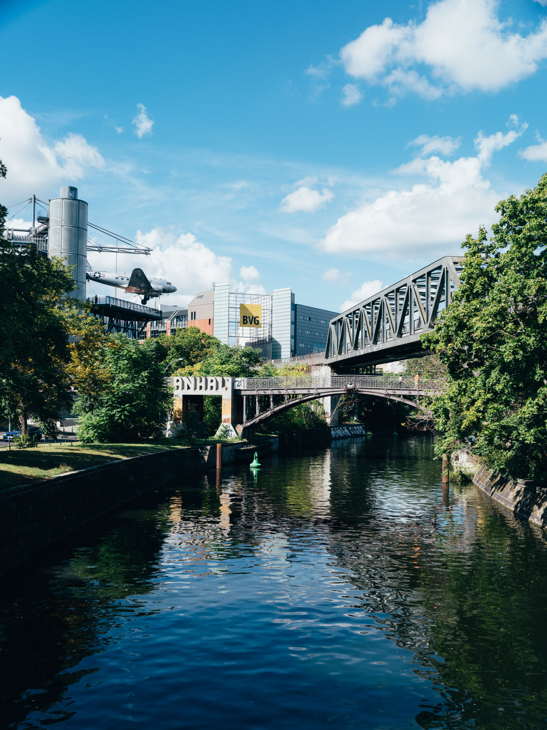 Blick auf das Deutsche Technikmuseum mit dem Rosinenbomber auf der Terrasse. Davor der Anhalter Steg und der Landwehrkanal.